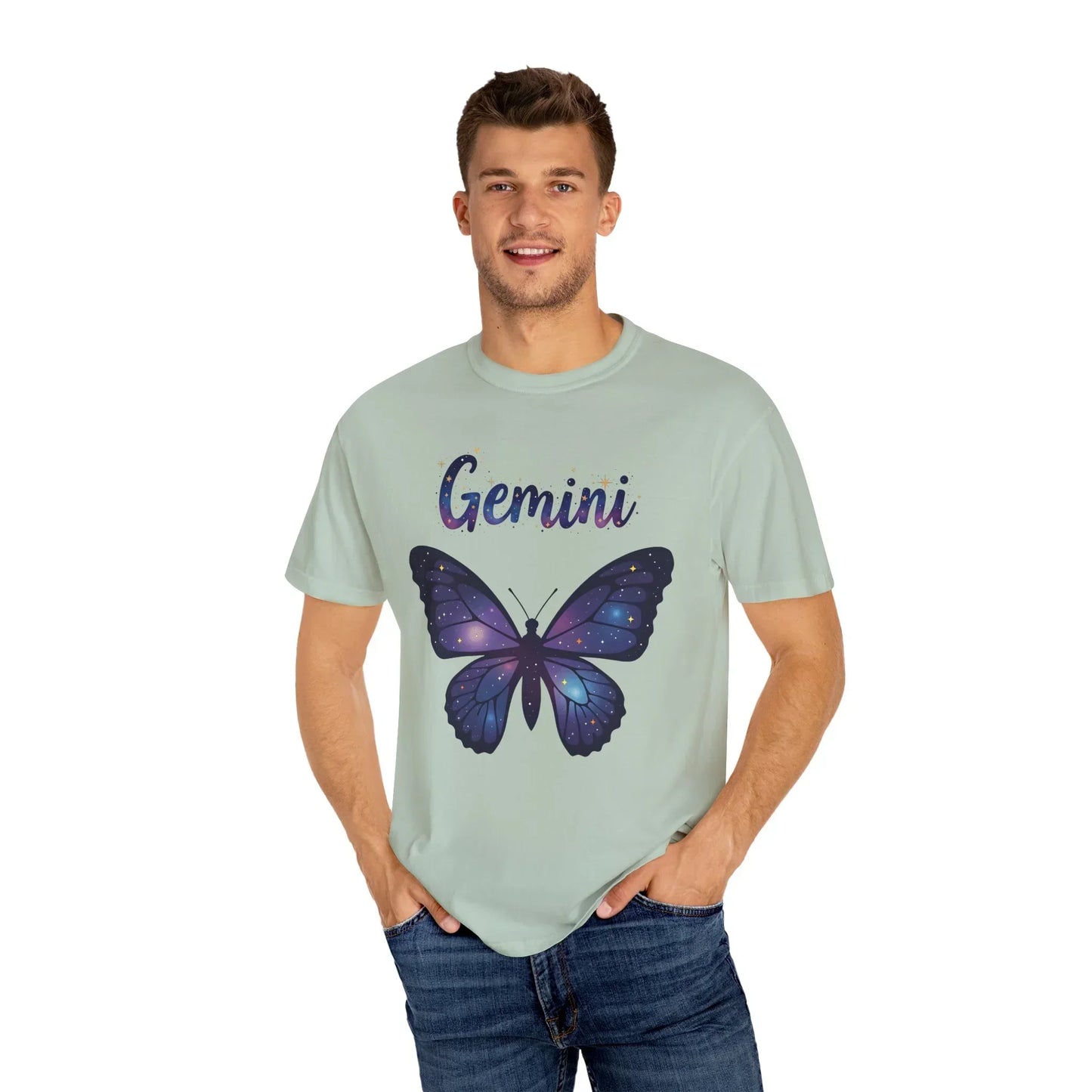 Smiling man wearing light green Gemini zodiac t-shirt with purple starry butterfly graphic and blue jeans